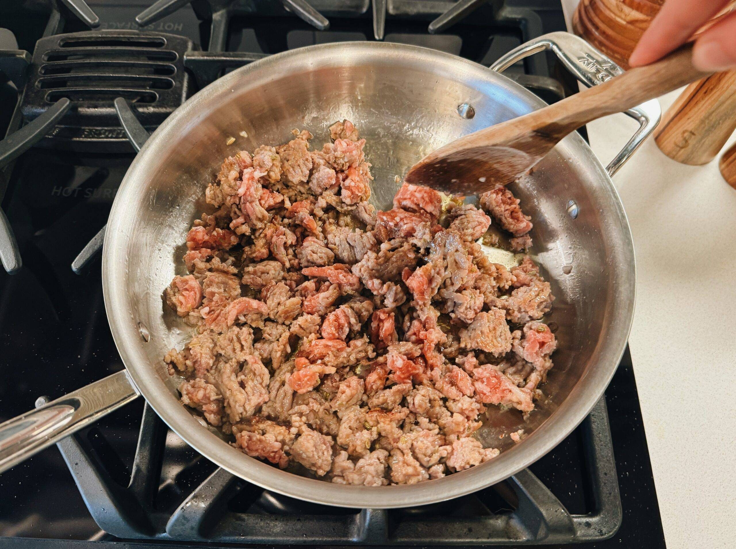Browning sausage in a pan.