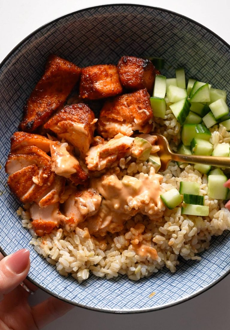 Air fryer chicken in a bowl with rice and cucumber.