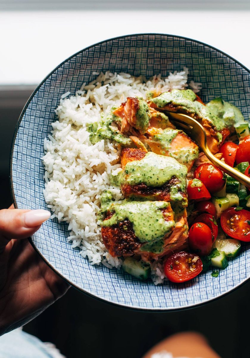 Salmon with basil sauce, tomato salad, and rice in a bowl